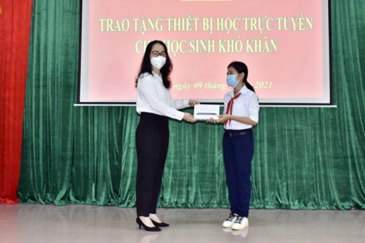 Bà Trần Thị Ngọc Châu, Giám đốc Sở GD-ĐT trao máy tính bảng cho em Trần Lê Minh Thư, HS Lớp 8.7 Trường THCS Đất Đỏ.