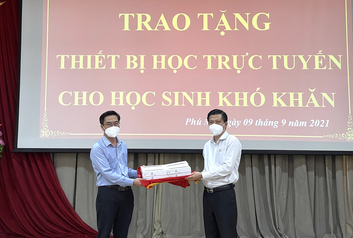 Ông Trần Văn Tuấn, Phó Chủ tịch UBND tinh (bên phải) trao máy tính bảng cho đại diện UBND TX.Phú Mỹ.để chuyển đến HS có hoàn cảnh khó khăn.