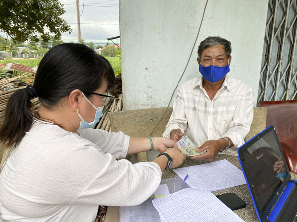 Bà Phương Mỹ Lương, công chức phụ trách LĐTBXH phường Hắc Dịch, TX.Phú Mỹ chi trả  trợ cấp thất nghiệp cho ông Dương Văn Nghĩa. Ành: MỸ LƯƠNG