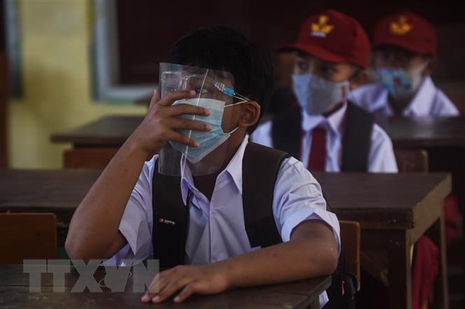 Học sinh đeo khẩu trang phòng lây nhiễm COVID-19 trong ngày đầu tiên quay lại trường học sau nhiều tháng do dịch bệnh COVID-19 tại Tây Java, Indonesia, ngày 6/9/2021.