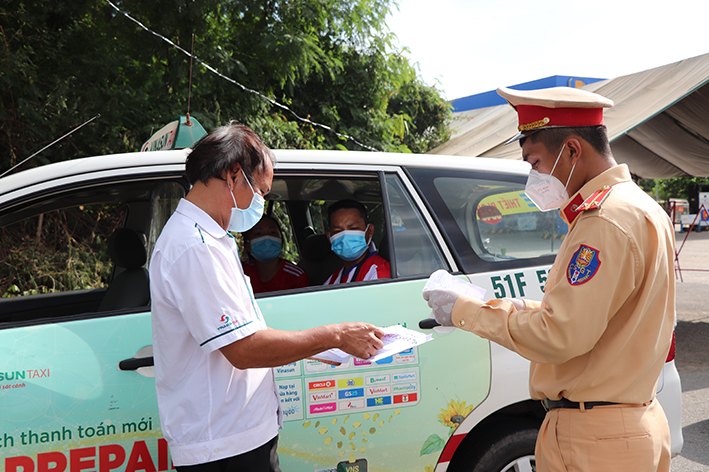 CSGT Công an huyện Long Điền kiểm tra giấy đi đường của một tài xế xe taxi khi lưu thông qua chốt kiểm soát dịch trên QL55 (vòng xoay Vũng Vằn).