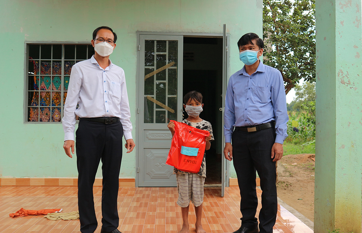 Ông Phan Minh Hợp, Bí thư Đảng ủy phường (bìa trái) và ông Nguyễn Quang Hoài, Chủ tịch UBND phường Hắc Dịch tặng điện thoại thông minh cho HS có hoàn cảnh khó khăn trên địa bàn.