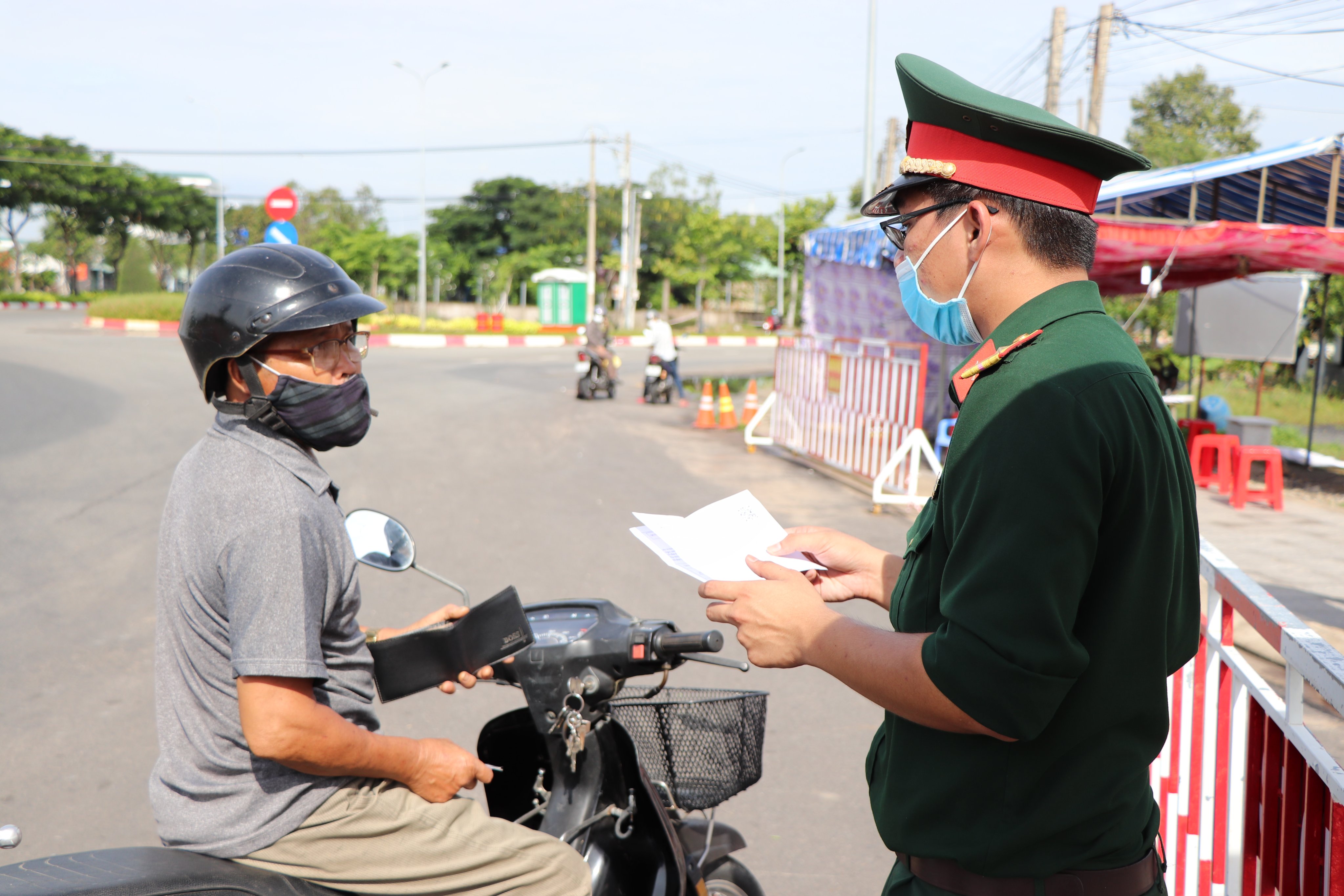 Lực lượng chức năng TP. Bà Rịa kiểm tra giấy tờ đi đường của người dân khi đi qua chốt kiểm soát dịch trên Tỉnh lộ 44A (đoạn giáp ranh TP. Bà Rịa và huyện Long Điền). Ảnh: ĐINH HÙNG