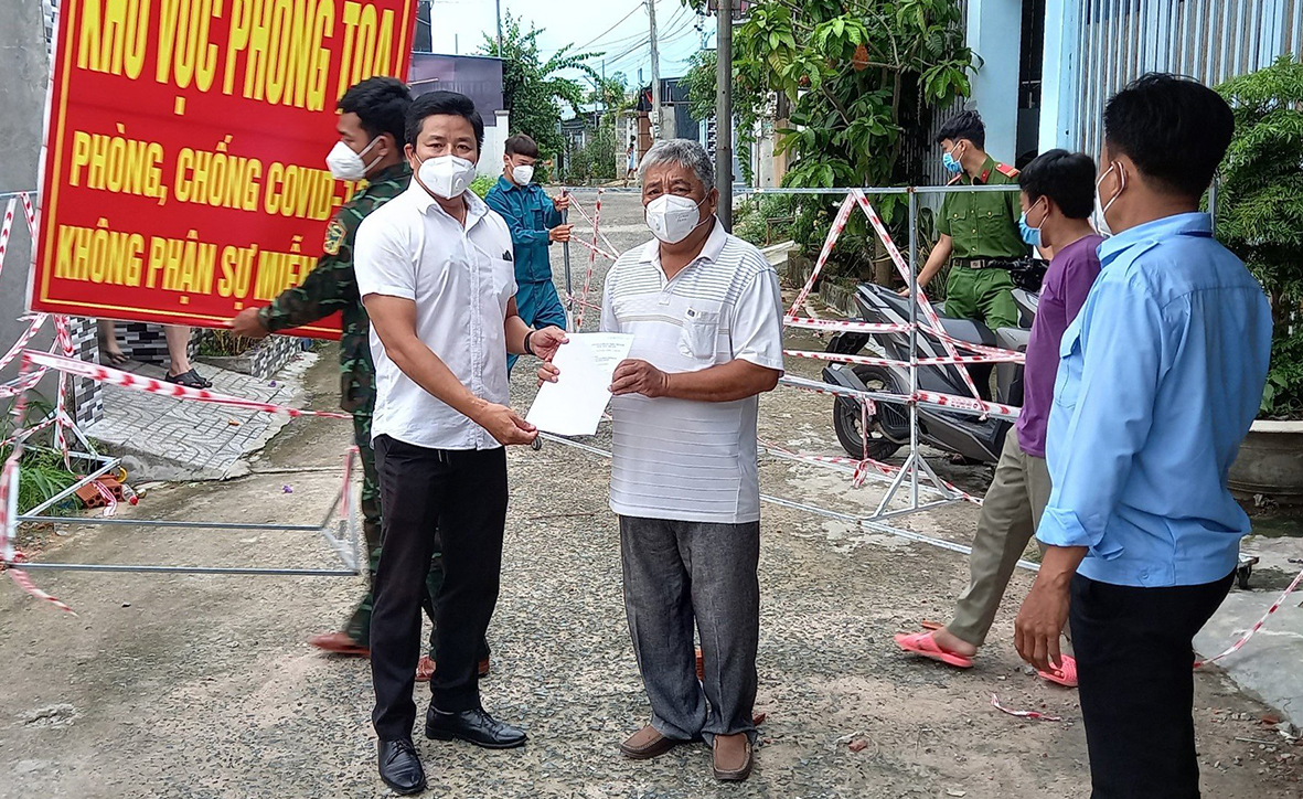 Ông Nguyễn Tăng Trường Duy (bên trái), Phó Chủ tịch UBND xã An Ngãi (huyện Long Điền) trao quyết định dỡ bỏ vùng phong tỏa cách ly y tế đối với khu Gia Phát thuộc tổ 10B, ấp An Thạnh, xã An Ngãi (huyện Long Điền) cho Ban Điều hành ấp An Thạnh.