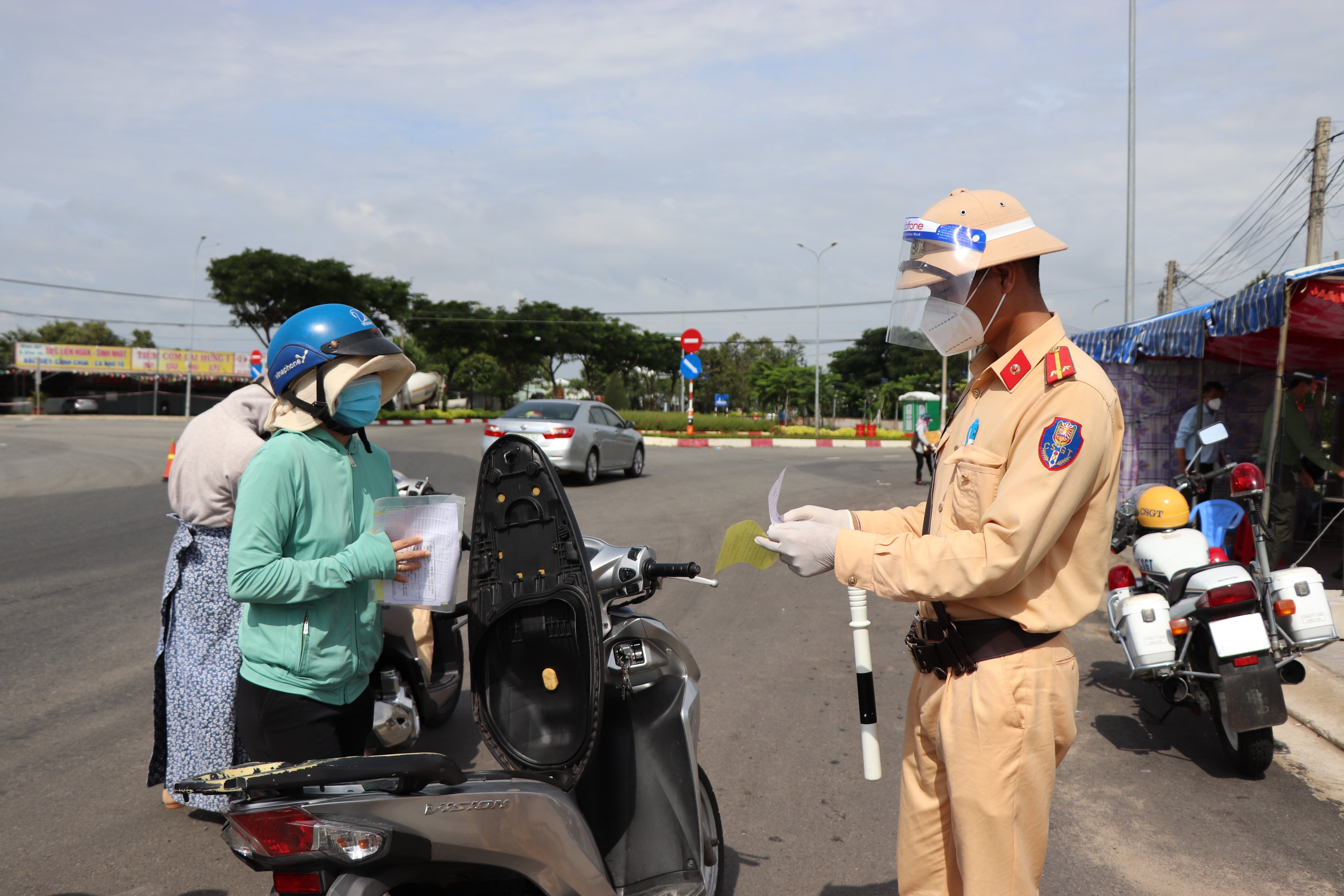 Lực lượng chức năng huyện Long Điền kiểm tra giấy tờ đi đường của người dân khi đi qua chốt kiểm soát dịch trên Tỉnh lộ 44A (vòng xoay Vũng Vằn). Ảnh: ĐINH HÙNG