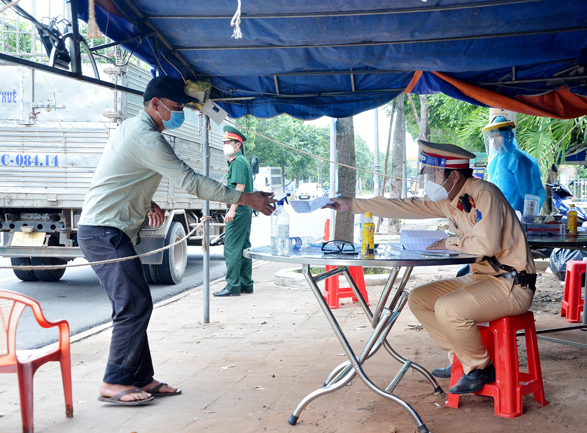 Lực lượng chức năng huyện Đất Đỏ kiểm soát phương tiện ra, vào huyện tại chốt trên Quốc lộ 55, huyện Đất Đỏ. Ảnh: VÂN ANH