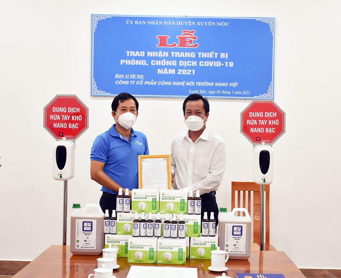 Ông Nguyễn Tuấn Anh, Chủ tịch HĐQT Công ty CP Công nghệ và môi trường nano Việt (trái) trao tặng vật tư y tế cho lãnh đạo huyện Xuyên Mộc.