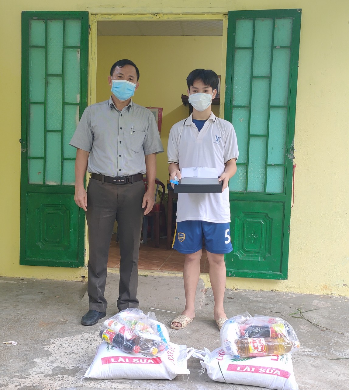 Ông Trương Trọng Ngân, Trưởng Ban Dân vận Thị ủy, Chủ tịch UBMTTQ Việt Nam thị xã thay mặt Thị ủy Phú Mỹ trao tặng máy tính bảng cho em Trần Quốc Cường.