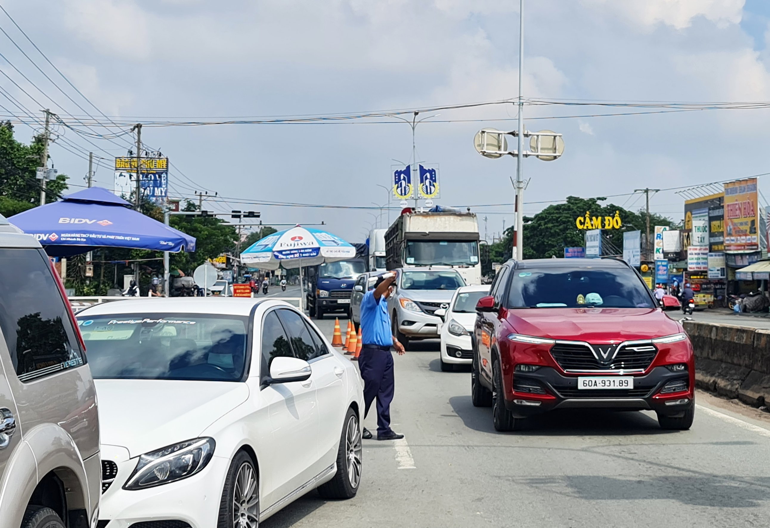 Lực lượng Thanh tra giao thông ra hiệu phương tiện vào khai báo y tế khi qua chốt kiểm soát y tế trên Quốc lộ 51.