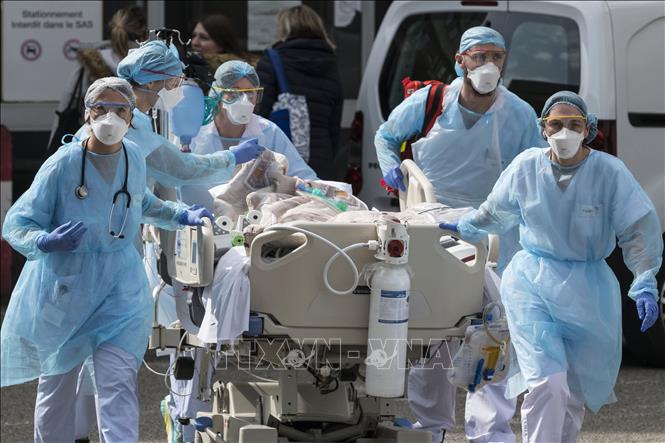 Nhân viên y tế chuyển bệnh nhân nhiễm COVID-19 tới một bệnh viện ở Mulhouse (Pháp) ngày 22/3/2020.