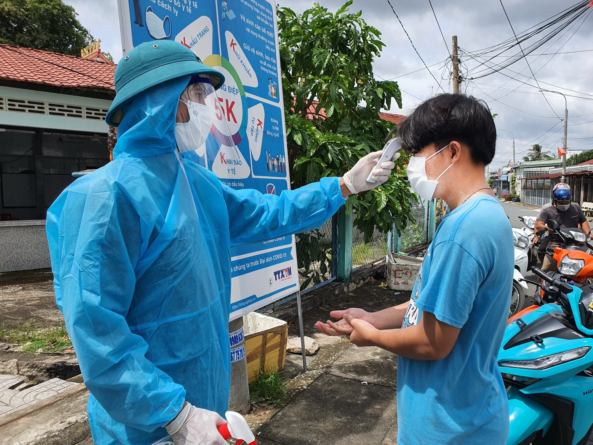 Lực lượng chức năng kiểm tra thân nhiệt cho người dân tham gia xét nghiệm sàng lọc  trên địa bàn xã Tân Hòa , TX.Phú Mỹ. Ảnh: MINH TÂM