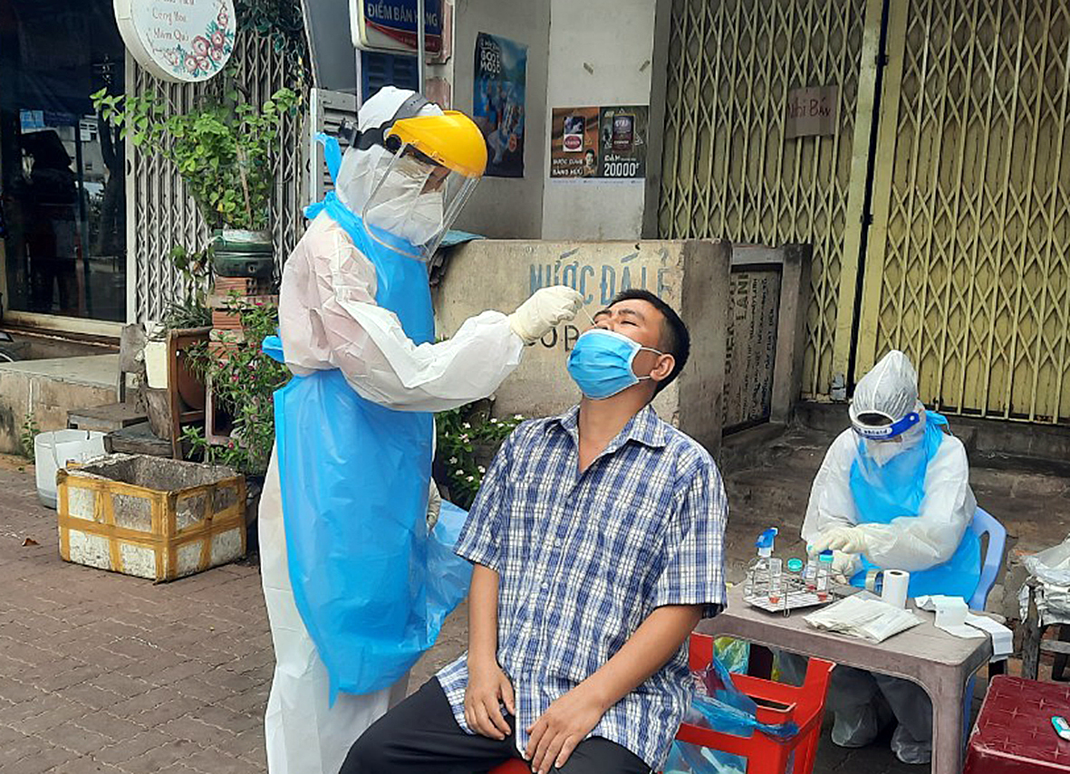 Nhân viên y tế lấy mẫu cho người dân sống trong khu nhà trọ tại khu phố Hải Sơn (thị trấn Long Hải) sáng 26/10.