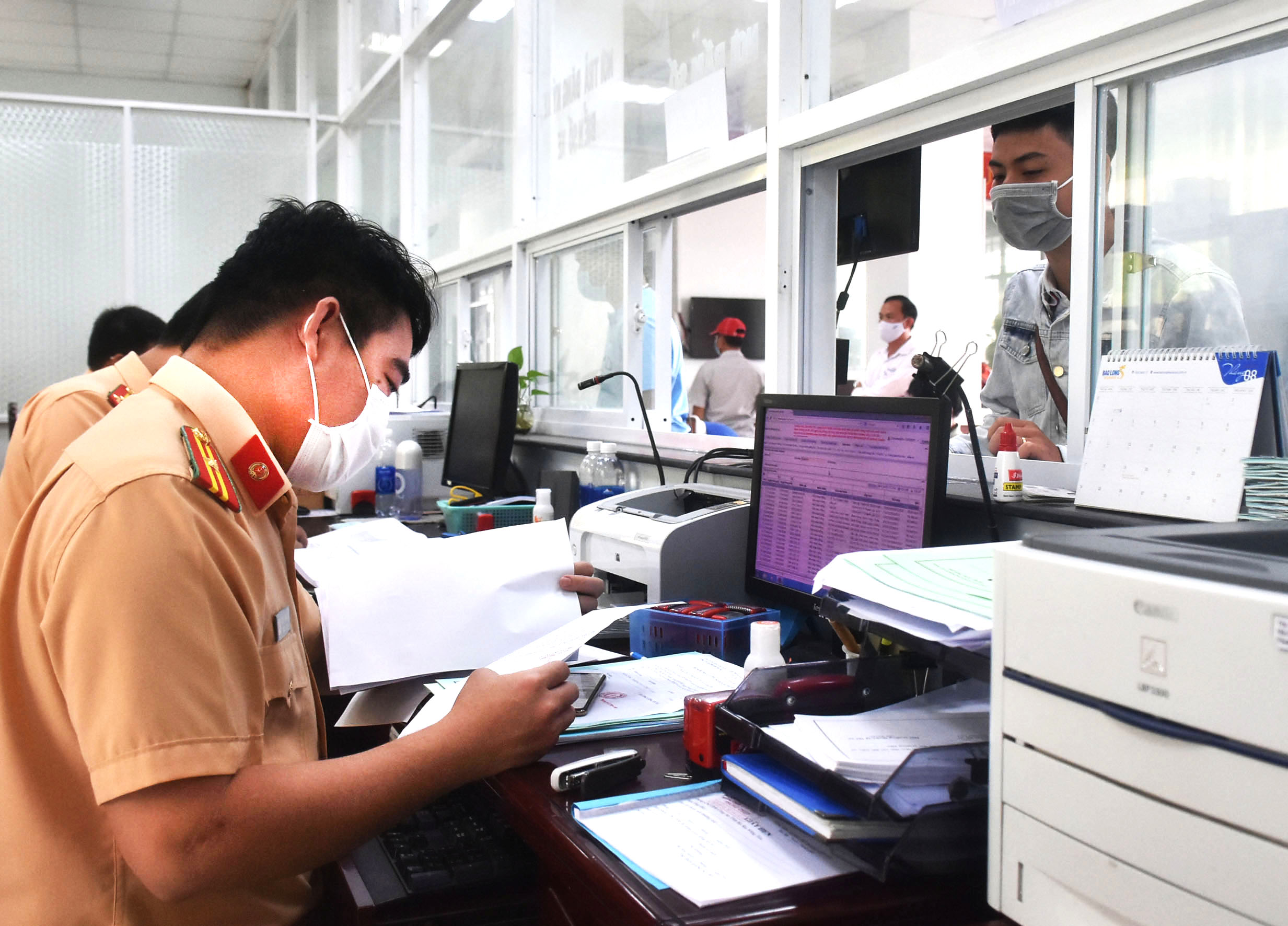 Cán bộ Phòng CSGT-Công an tỉnh tiếp nhận hồ sơ đăng ký biển số cho người dân.
