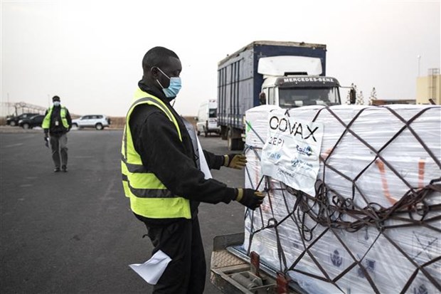 Nhân viên bốc dỡ lô vắc xin ngừa COVID-19 của hãng AstraZeneca/Oxford, được viện trợ theo chương trình COVAX, tại Dakar (Senegal).