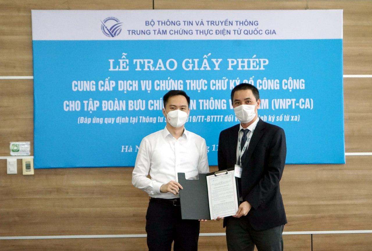 Ông Nguyễn Thiện Nghĩa (trái), Phó Giám đốc phụ trách Trung tâm Chứng thực điện tử Quốc gia trao giấy phép cung cấp dịch vụ chữ ký số từ xa cho đại diện VNPT.