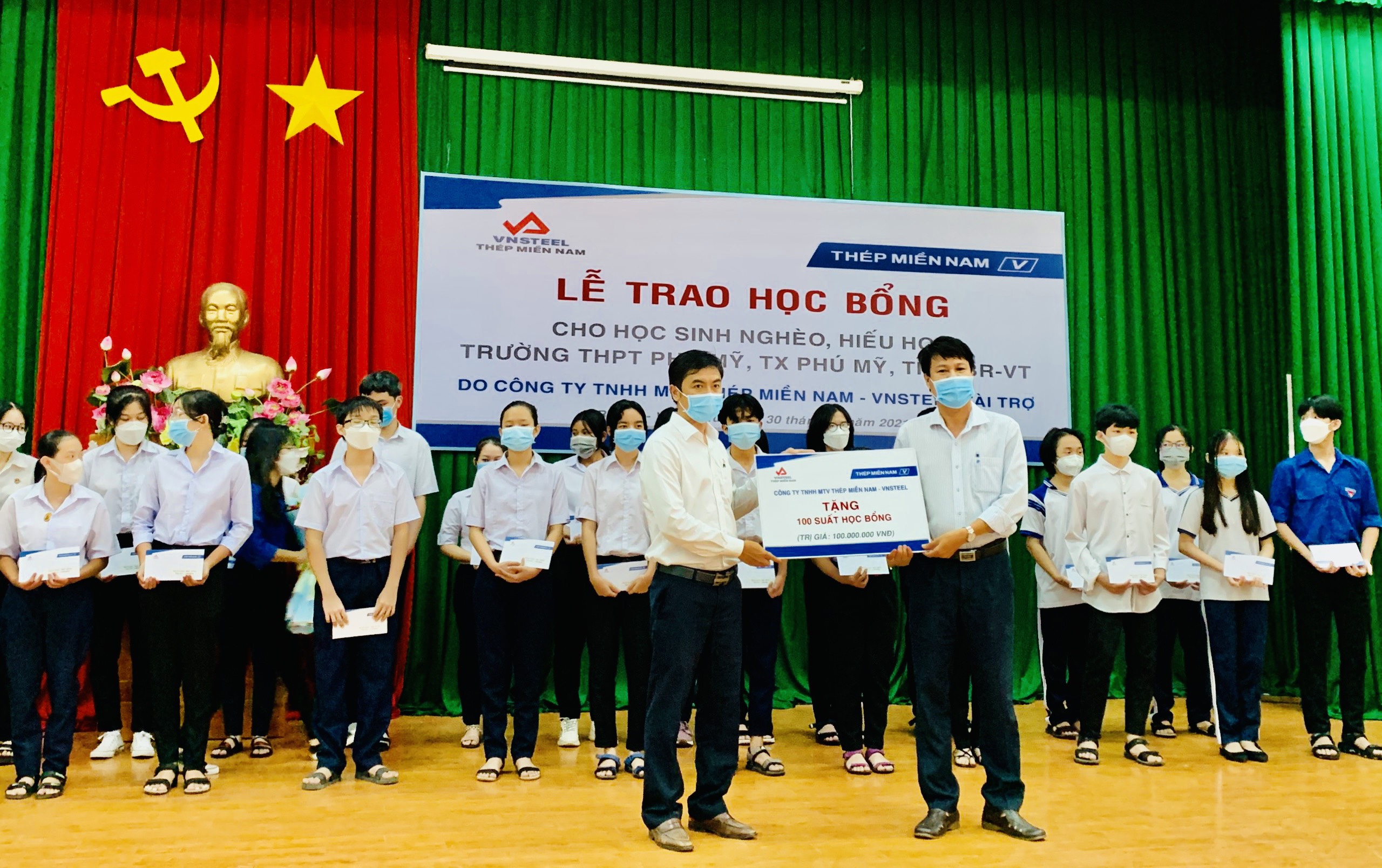 Ông Tô Vĩnh Hưng, Phó Tổng Giám đốc Công ty TNHH MTV Thép miền Nam (trái) trao bảng tượng trưng 100 suất học bổng cho trường THPT Phú Mỹ (TX. Phú Mỹ)