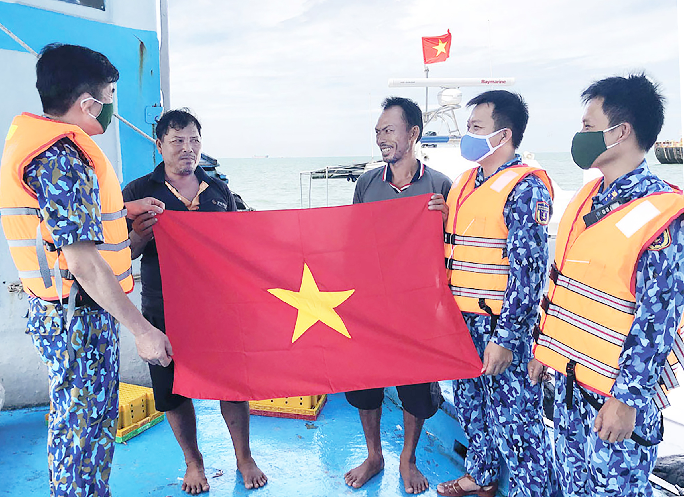 Cán bộ, chiến sĩ Bộ Tư lệnh Vùng CSB 3 tặng cờ Tổ quốc cho ngư dân.
