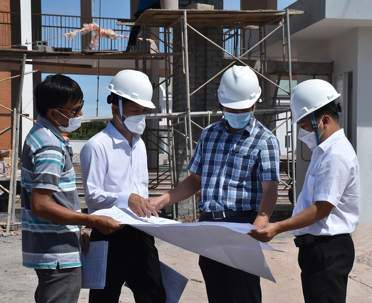 Đại diện Ban QLDA Đầu tư xây dựng huyện Xuyên Mộc (thứ hai, từ phải qua) kiểm tra bản thiết kế, thực hiện giám sát tại công trình Trường THCS Hòa Hiệp 2 (xã Hòa Hiệp).