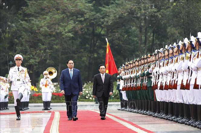 Thủ tướng Phạm Minh Chính và Thủ tướng Lào Phankham Viphavanh duyệt Đội danh dự Quân đội nhân dân Việt Nam. Ảnh: Dương Giang/TTXVN