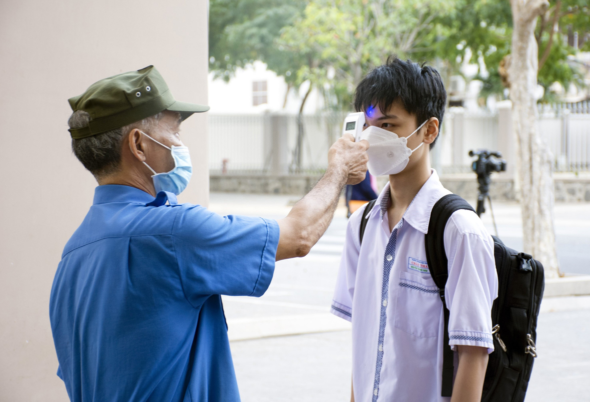 Các em HS lớp 12 của Trường THPT Châu Thành, TP. Bà Rịa đều được kiểm tra thân nhiệt trước khi vào lớp học.