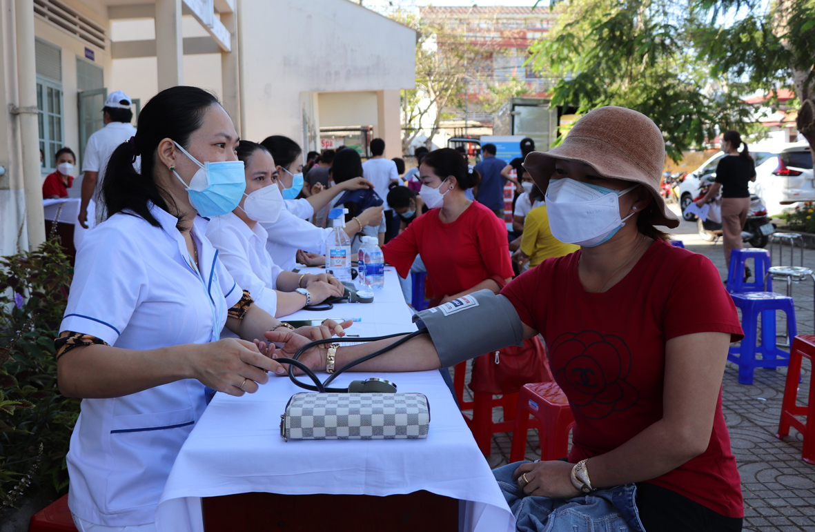 Nhân viên y tế kiểm tra sức khỏe người tham gia hiến máu.