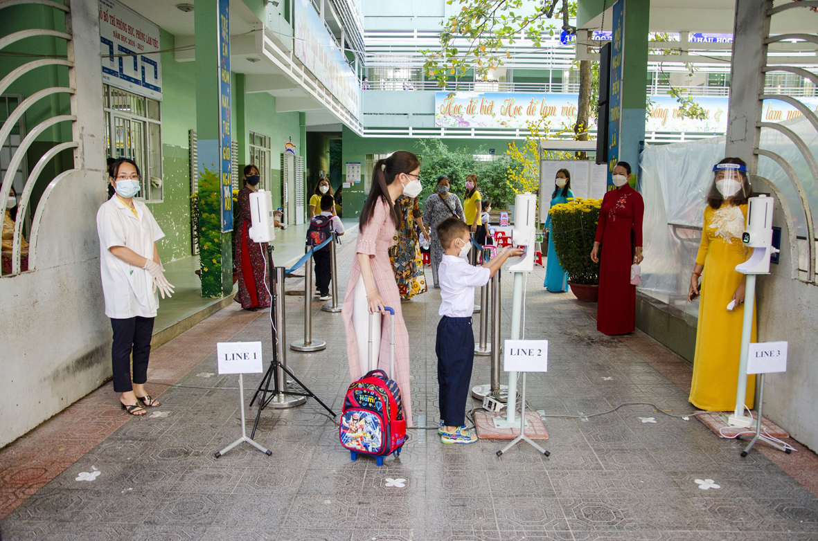 Các trường học chú trọng phân luồng HS và thực hiện các biện pháp 5k ngay tại cổng ra vào. Trong ảnh: GV, nhân viên y tế trường TH Đoàn Kết, TP.Vũng Tàu đón HS đến trường sáng 14/2. Ảnh: BẢO KHÁNH.