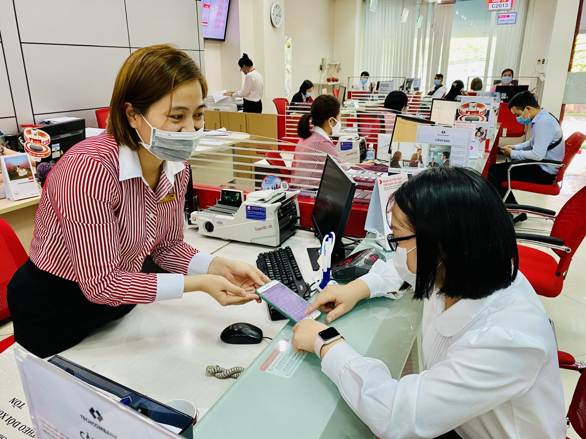 TP. Vũng Tàu khuyến khích người dân mua sắm trên các sàn thương mại điện tử và thanh toán không dùng tiền mặt. Trong ảnh: Nhân viên Ngân hàng Techcombank hướng dẫn khách hàng tải các ứng dụng để thanh toán online.