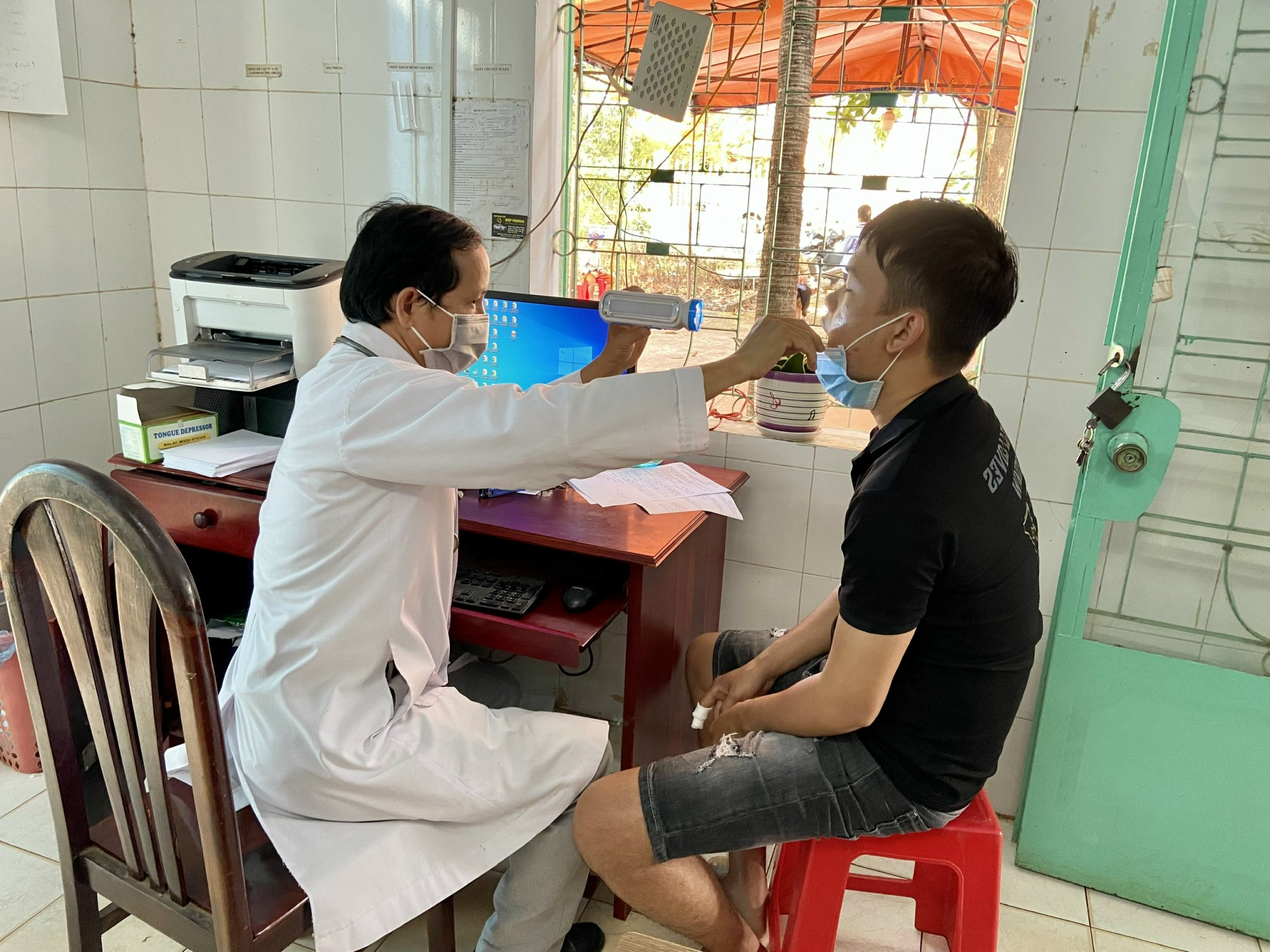 Bác sĩ Hoàng Minh Thành khám bệnh cho người dân tại Trạm Y tế xã Hòa Hiệp.