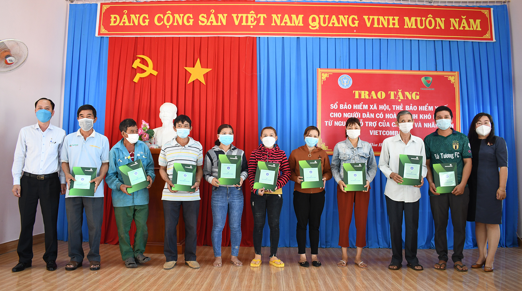 Bà Nguyễn Hồng Hạnh (bìa phải), Phó Giám đốc BHXH tỉnh và đại diện Vietcombank Chi nhánh BR-VT (bìa trái) trao sổ BHXH cho người dân xã Hòa Hiệp (huyện Xuyên Mộc).