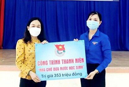 Chị Nguyễn Thị Đường, Bí thư xã đoàn Tân Hoà trao bảng tượng trưng tặng công trình “Nhà chờ đưa rước học sinh” cho cô Trần Thị Nhiễm, hiệu trưởng Trường THCS Hùng Vương.