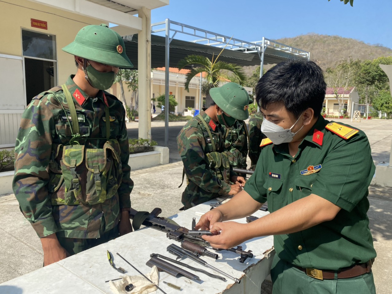 Cán bộ Trung đoàn Minh Đạm hướng dẫn chiến sĩ mới động tác lau chùi, bảo quản súng tiểu kiên AK.