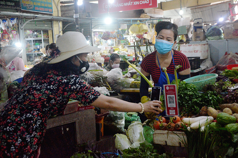 Để bắt kịp xu hướng tiêu dùng mới, nhiều tiểu thương tại các chợ truyền thống vừa kinh doanh trực tiếp và online qua zalo, facebook. Trong ảnh: Chị Nguyễn Thị Bích (trái) tiểu thương chợ Đất Đỏ ngoài bán hàng tại sạp còn bán hàng online.