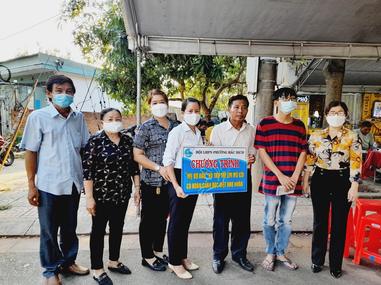 Đại diện Hội LHPN phường Hắc Dịch, trao bảng tượng trưng mẹ đỡ đầu và sổ tiết kiệm cho em Nguyễn Châu Tấn Cường (SN 2003, KP.Trảng Lớn, TX.Phú Mỹ) (áo sọc).