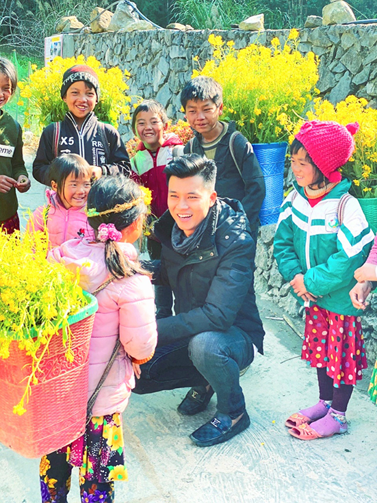 Anh Đại Quang trò chuyện và tặng quà cho các em nhỏ tại tỉnh Hà Giang.