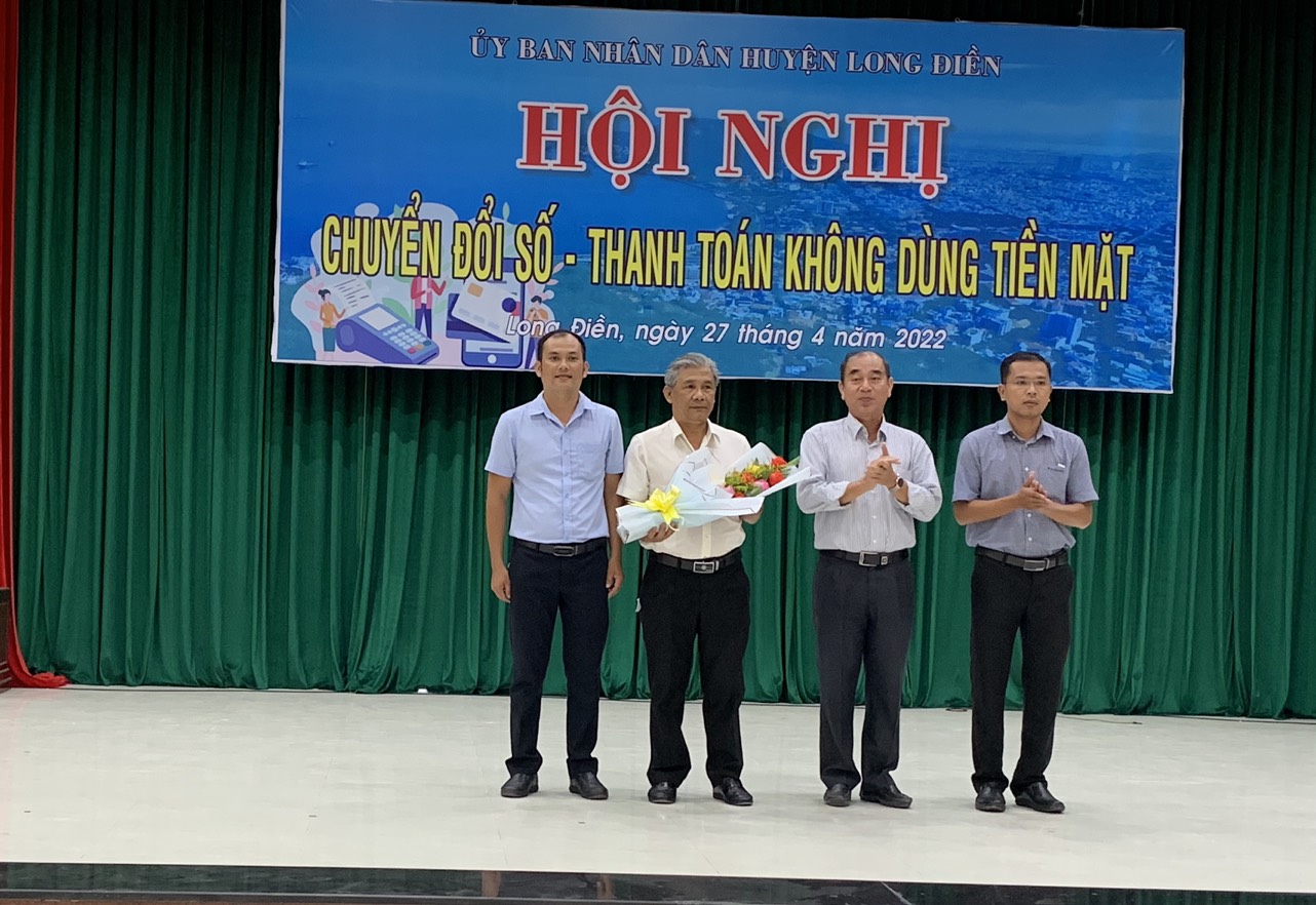 Ông Lâm Văn Hồng, Chủ tịch UBND huyện Long Điền tặng hoa cảm ơn đại diện “Tổ giúp việc, triển khai công nghệ số cộng đồng huyện Long Điền” tại hội nghị.