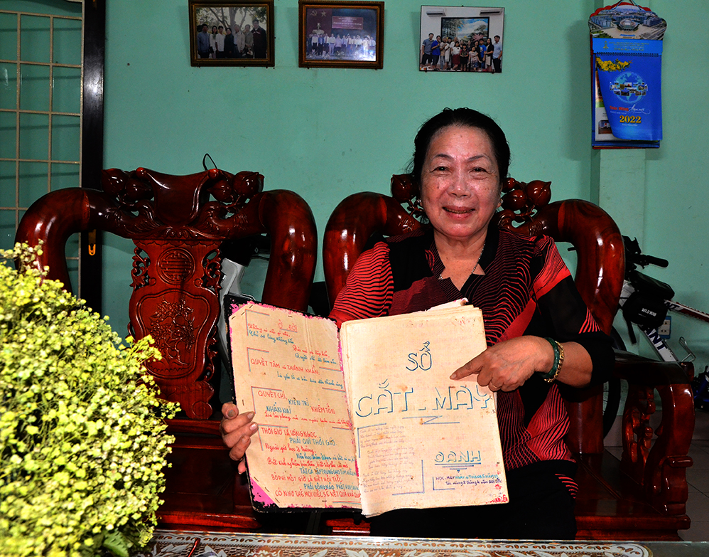 Bà Nguyễn Thị Kim Oanh lưu giữ cuốn sổ cắt may cờ giải phóng làm kỷ niệm.