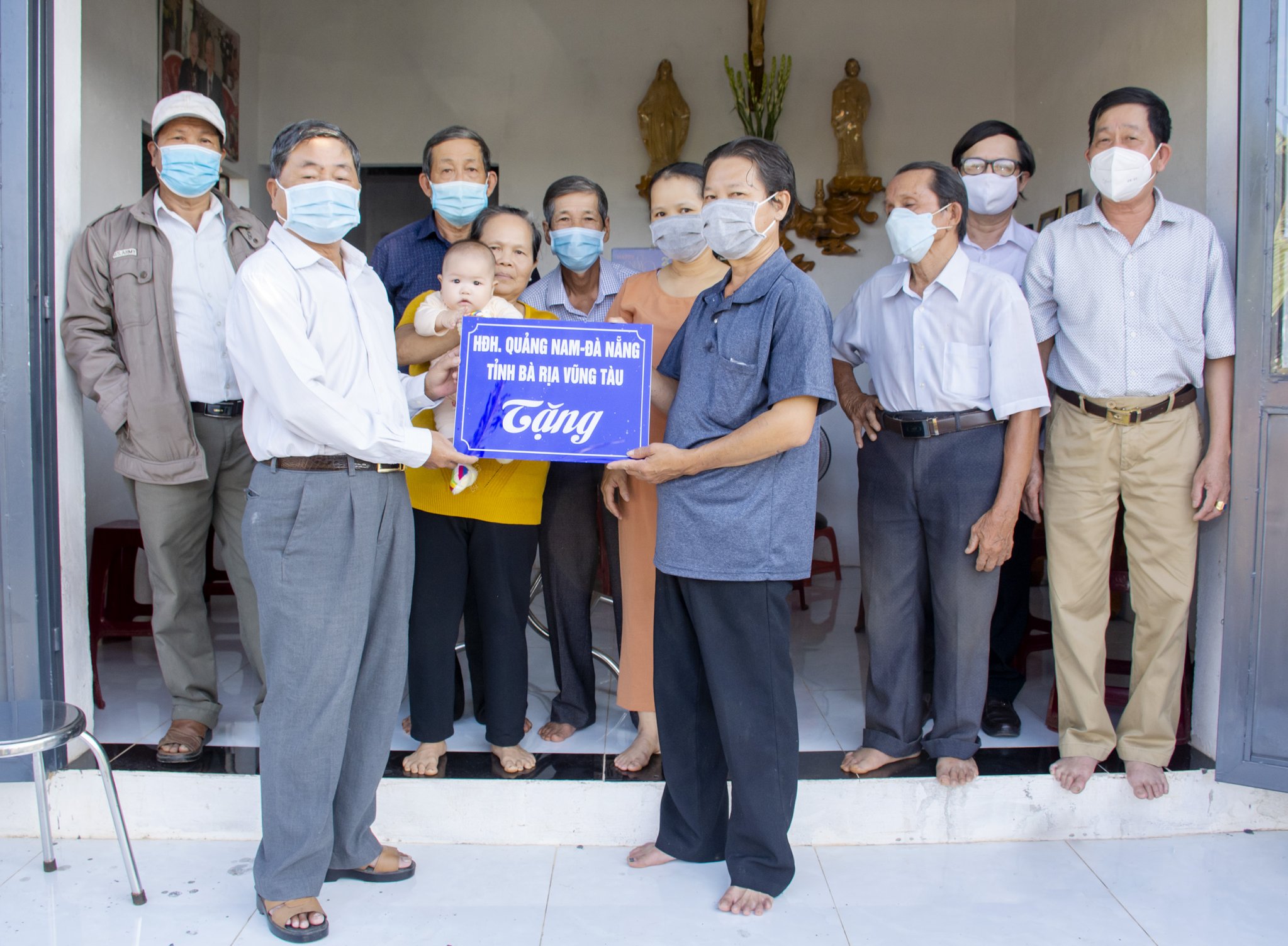 Trung tướng Châu Văn Mẫn, Anh hùng LLVTND, Chủ tịch Hội Đồng hương Quảng Nam - Đà Nẵng tại BR-VT (hàng đầu, thứ nhất từ trái qua) trao tặng Bảng tượng trưng hoàn thành xây mới ngôi nhà tình thương và tặng quà cho gia đình ông Nguyễn Ngọc Ánh (quê quán huyện Quế Sơn, tỉnh Quảng Nam), đang sinh sống tại TT. Ngãi Giao, huyện Châu Đức, ngày 24/12/2021. Ảnh: BẢO KHÁNH