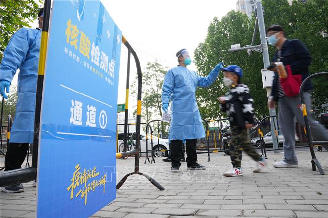 Nhân viên y tế hướng dẫn người dân tại một điểm xét nghiệm COVID-19 ở Bắc Kinh, Trung Quốc, ngày 29/4/2022.