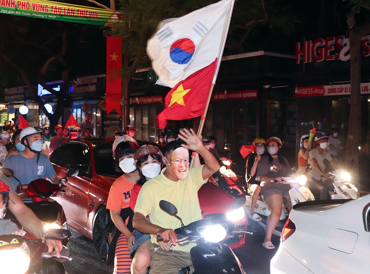 Người hâm mộ đeo mặt nạ thầy Park xuống đường ăn mừng Huy chương Vàng của U23 Việt Nam.
