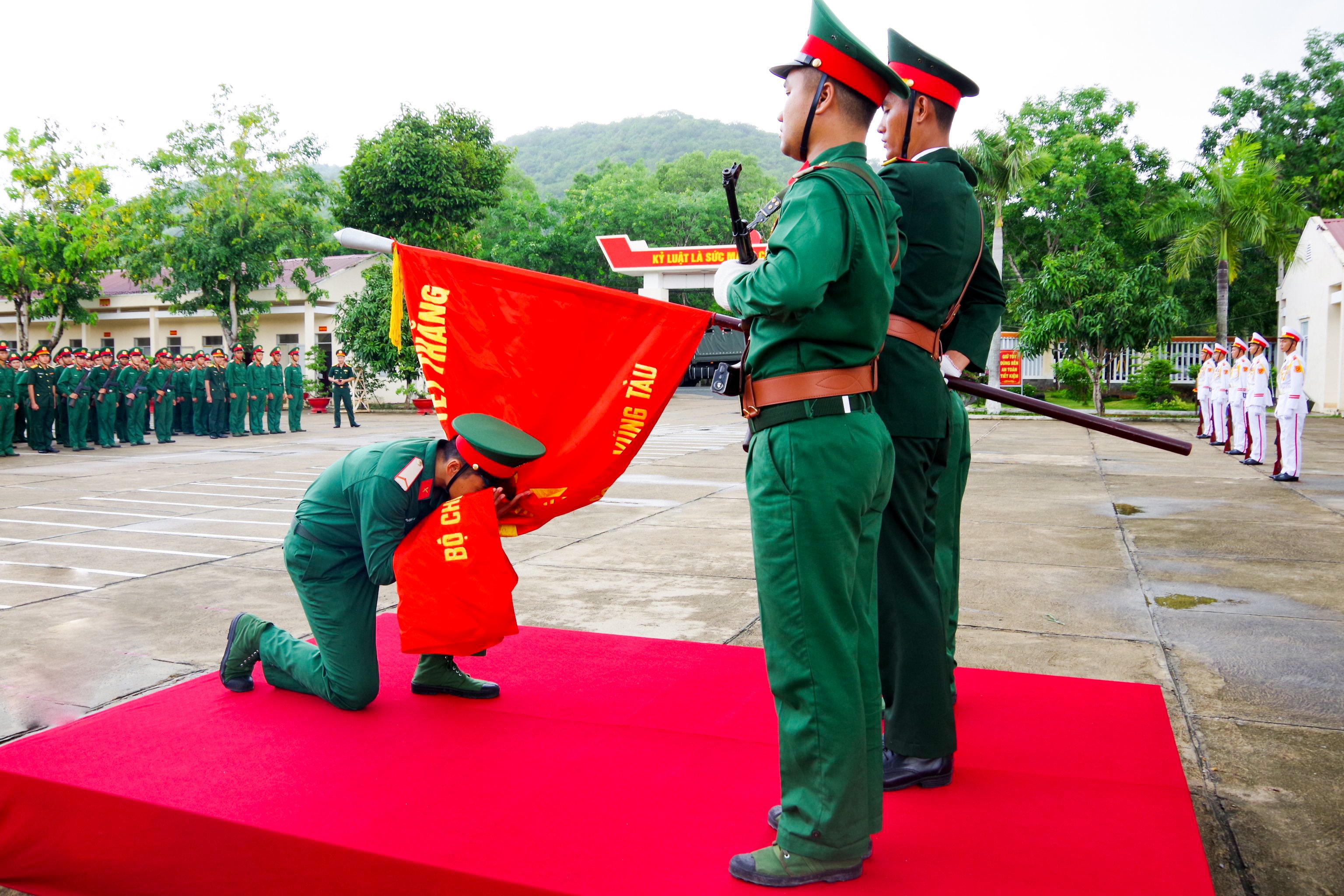 Chiến sĩ mới hôn lên cờ Quyết thắng sau khi đọc 10 lời thề của quân nhân. Ảnh: NHẬT LINH