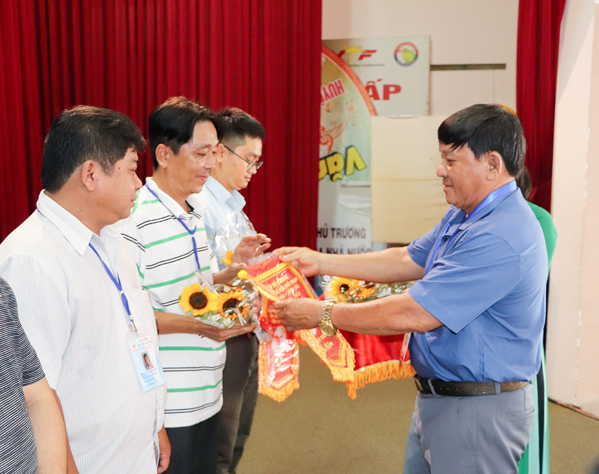 Ông Đặng Văn Cường, Giám đốc Trung tâm Huấn luyện và Thi đấu TDTT tỉnh tặng hoa, cờ lưu niệm cho các đoàn dự giải.