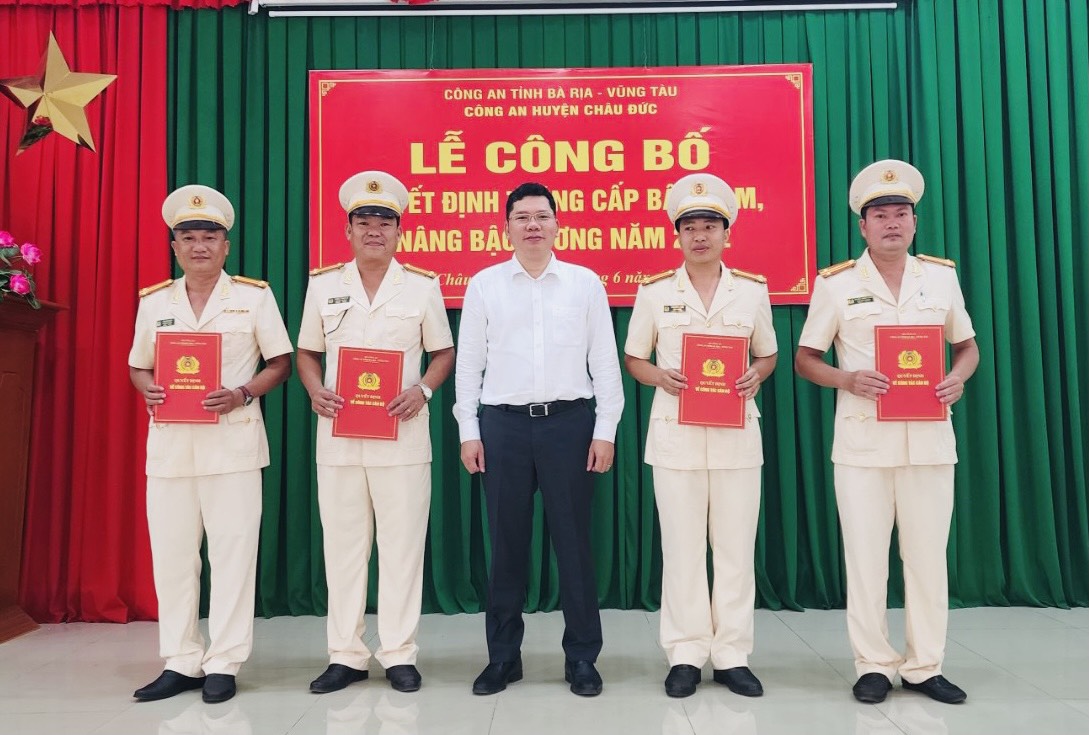 Ông Hoàng Nguyên Dinh, Chủ tịch UBND huyện Châu Đức trao quyết định nâng bậc lương Trung tá vượt khung lần 1 cho các cán bộ Công an huyện.