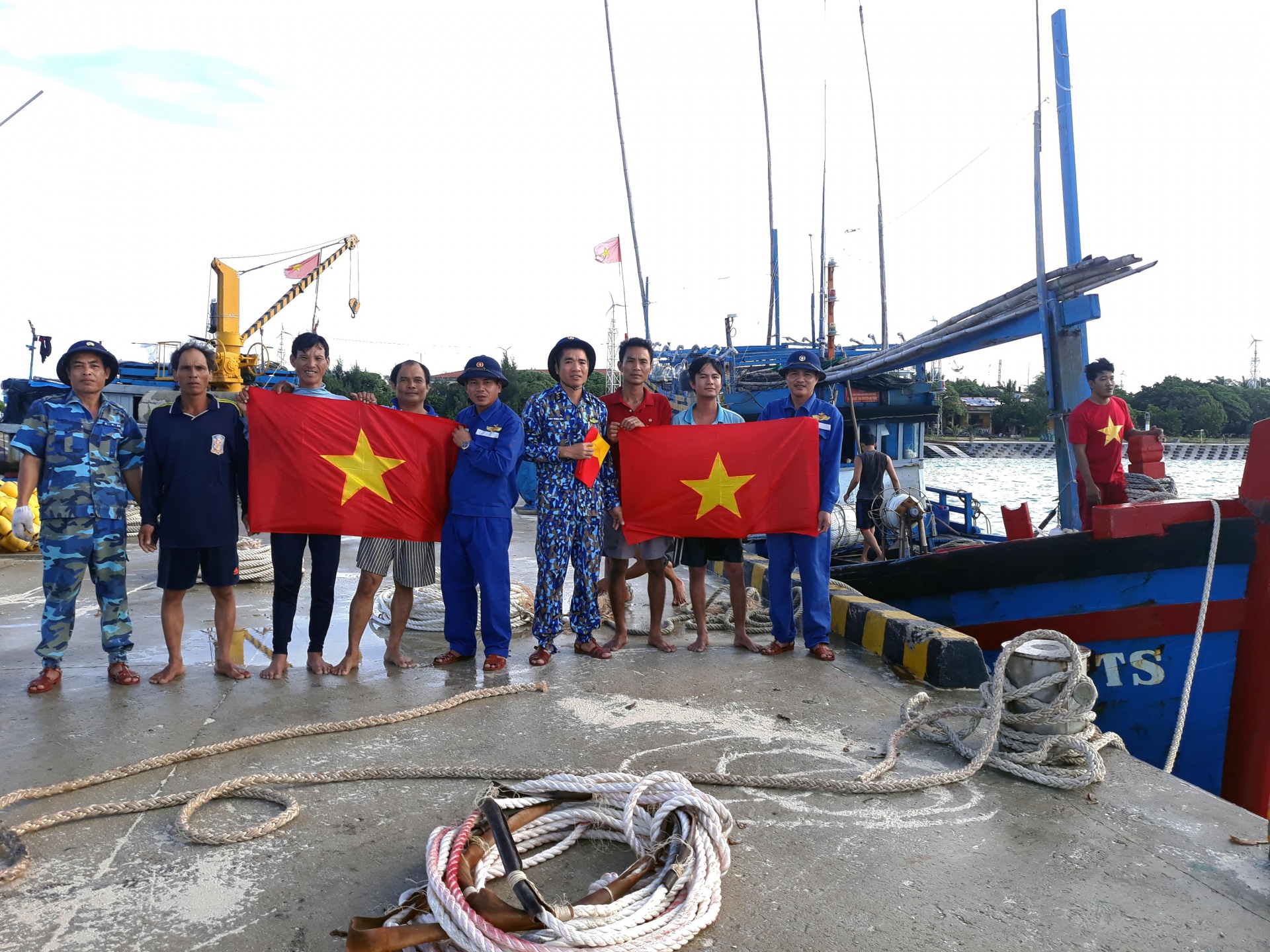 Nhân viên Trung tâm Dịch vụ hậu cần - kỹ thuật đảo Sinh Tồn tặng cờ Tổ quốc cho ngư dân.