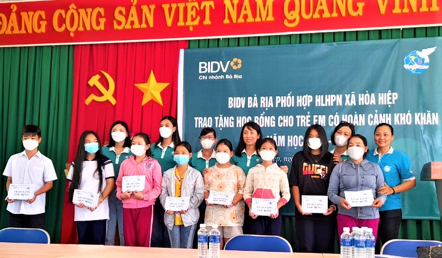 Đại diện Ngân hàng BIDV Chi nhánh Bà Rịa, Hội LHPN xã Hòa Hiệp (huyện Xuyên Mộc) tặng học bổng cho các em HS nghèo, khó khăn.
