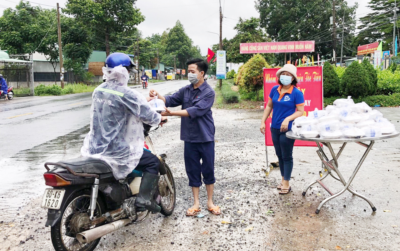 Các thành viên Nhóm thiện nguyện Tóc Tiên trao tặng bữa sáng đến người khó khăn.