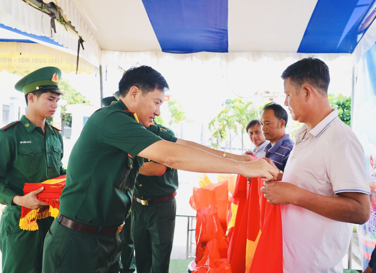 Đại diện Bộ CHQS tỉnh trao cờ Tổ quốc cho chủ phương tiện, ngư dân trên địa bàn huyện.