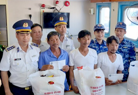 Lãnh đạo Bộ Tư lệnh Vùng Cảnh sát biển 3 tặng quà ngư dân sau khi đưa lên bờ.