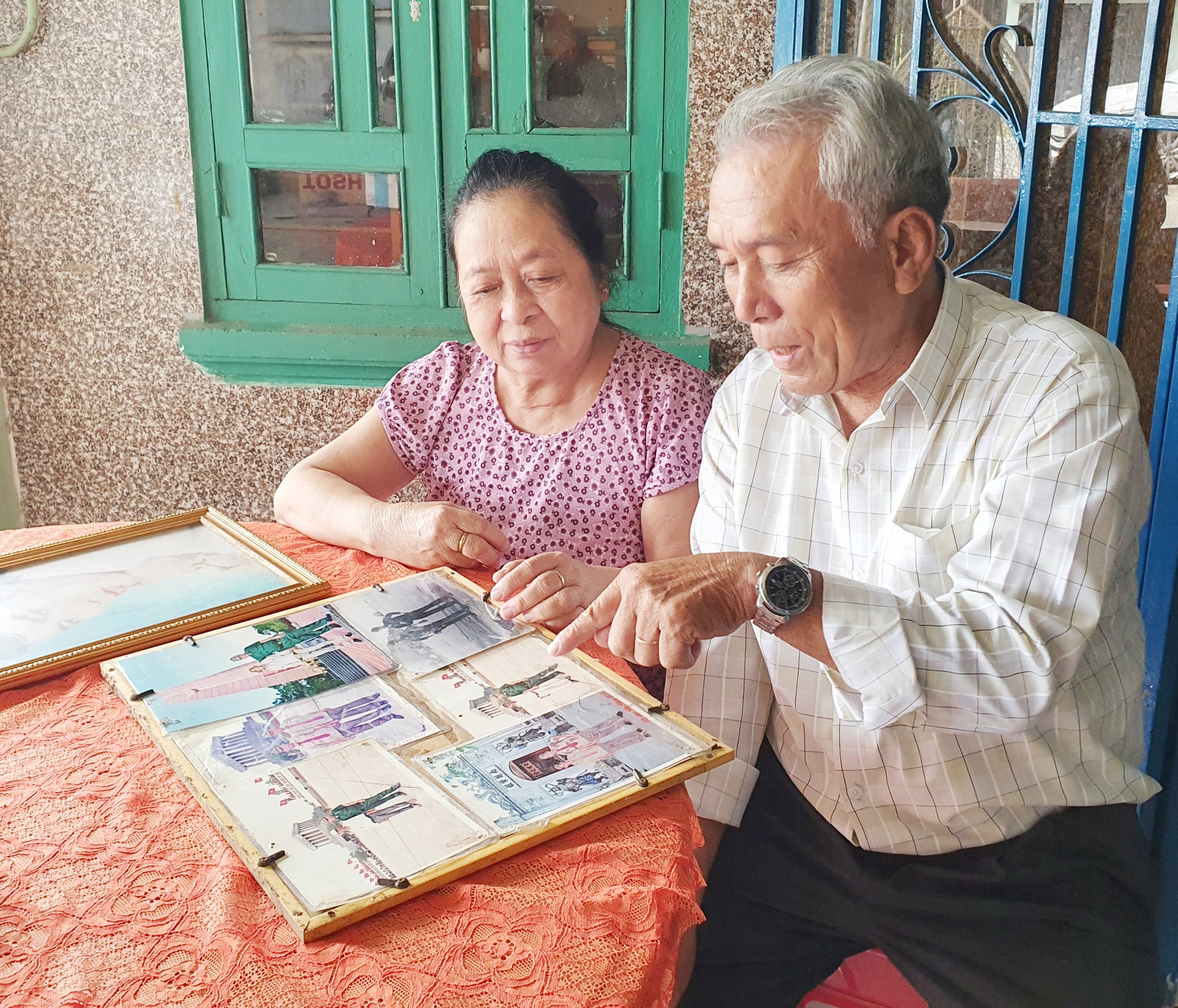 Thương, bệnh binh Lê Văn Thường cùng vợ ôn lại kỷ niệm những năm tháng chiến đấu gian khổ.
