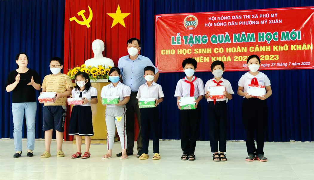 Đại diện Hội Nông dân phường Mỹ Xuân tặng quà cho các em học sinh.