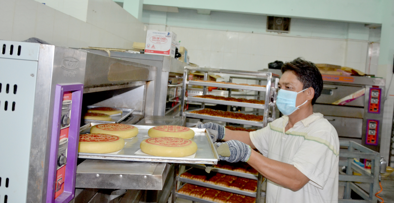 Nhân viên cơ sở sản xuất bánh Trung thu Văn Tập Hòa cẩn thận đưa từng vỉ bánh ra lò.